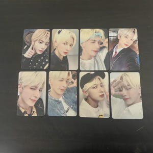 May include: Eight rectangular photo cards featuring a young person with blonde hair. The cards show the person in various poses, wearing different outfits, including a black jacket, a denim jacket, and a baseball cap. The background is a solid color.