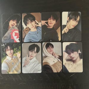 May include: Set of eight rectangular photo cards featuring a young person in various poses and outfits. The cards showcase the subject in casual wear, including hoodies and shirts, with different backgrounds.