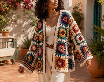 May include: A long-sleeved open-front cardigan constructed from multi-colored crochet granny squares in shades of cream, yellow, red, teal, and dark purple, worn over a cream-colored tank top and matching cream-colored wide-leg trousers.
