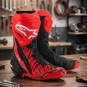 Puede incluir: Par de botas de moto rojas y negras con detalles de logotipo blancos. Las botas están hechas de una combinación de cuero y materiales sintéticos, con un enfoque en la protección y el estilo. Botas diseñadas para montar en moto.