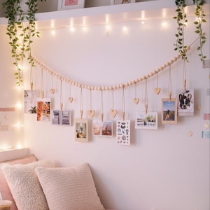 Puede incluir: Un letrero de madera hecho a mano con la palabra "Welcome" escrita a mano. El letrero está pintado de blanco con un acabado envejecido, y una pequeña hoja verde está adherida en la parte superior. Diseñado para uso interior o exterior.