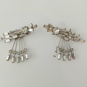 Pendientes de clip MCM Atomic Burst con cristales transparentes y diamantes de imitación en tono plateado.