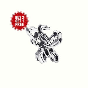 May include: A silver charm with a cartoon character design. The charm has a detailed, polished finish. The background is white. A red starburst graphic with the text "BUY 2 GET 1 FREE" is in the upper left corner.