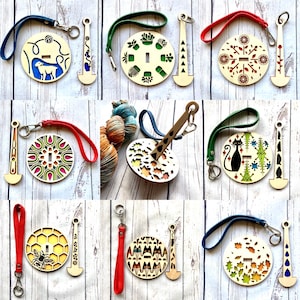 May include: Nine different wooden yarn bowl sets with a variety of designs. Each set includes a bowl with a unique design and a wooden hook. The designs include a sheep, a mandala, a cat, a bee, a geometric pattern, a snowflake, a leaf pattern, a flower pattern, and a geometric pattern.