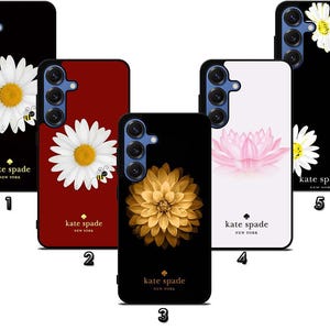 May include: A collection of phone cases featuring floral designs. The cases showcase a variety of flowers, including daisies, a lotus, and a golden dahlia. Each case has the "kate spade NEW YORK" logo.