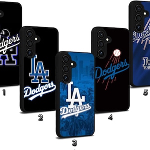 Puede incluir: Una colección de fundas negras para teléfonos con el logotipo de los Dodgers de Los Ángeles y varios diseños. Las fundas muestran el nombre del equipo, el logotipo y gráficos temáticos de béisbol en blanco y azul. Algunas fundas tienen un fondo de paisaje urbano o palmeras.