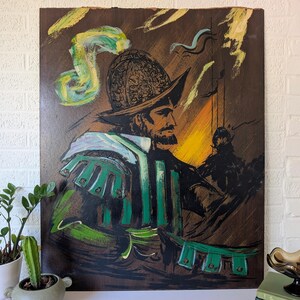 May include: An artistic painting of a man in a helmet and armor, rendered in shades of brown, green, and yellow. The artwork features a detailed depiction of the man's face and attire, with brushstrokes creating a textured effect. The painting evokes a historical or fantasy theme.