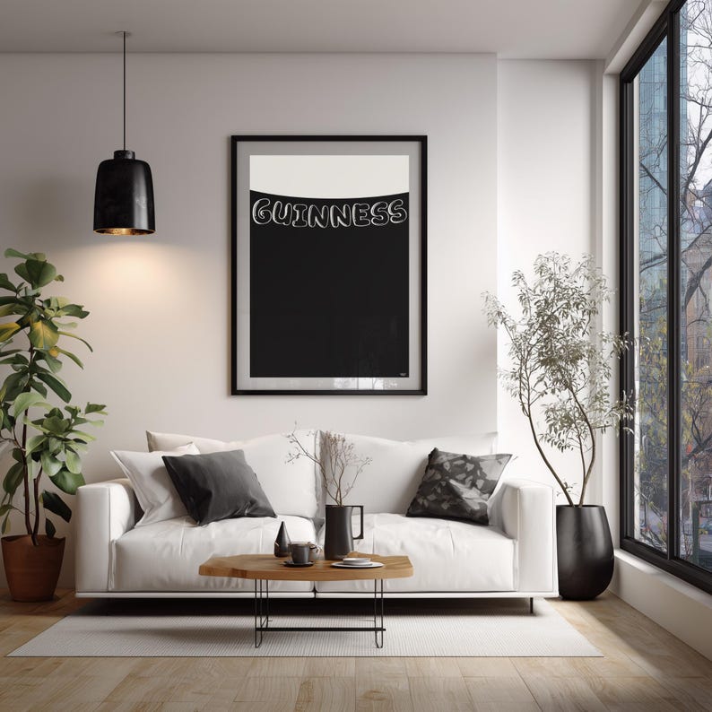Puede incluir: Un cuadro con una impresi&oacute;n art&iacute;stica de Guinness en blanco y negro. La impresi&oacute;n muestra el logotipo de Guinness en blanco sobre un fondo negro, con una secci&oacute;n superior blanca. La impresi&oacute;n cuelga sobre un sof&aacute; blanco en un sal&oacute;n moderno.