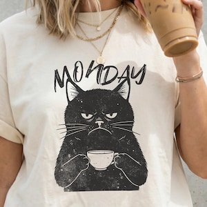 May include: A set of three ceramic mugs with a speckled, matte finish. The mugs are in shades of cream, light gray, and dark gray. Each mug has a simple, minimalist design, perfect for coffee or tea.