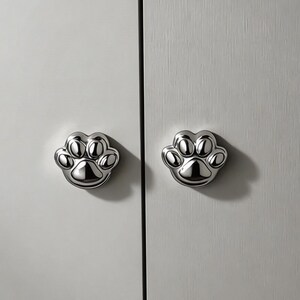 Pomello per armadio a forma di zampa di gatto in ottone massiccio forgiato, con bordo arrotondato e superficie antigraffio.