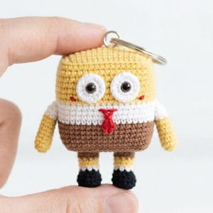 May include: A white ceramic mug with a black handle and the text "But First, Coffee" in a bold, black font. The mug is set against a blurred background, suggesting a cosy setting.