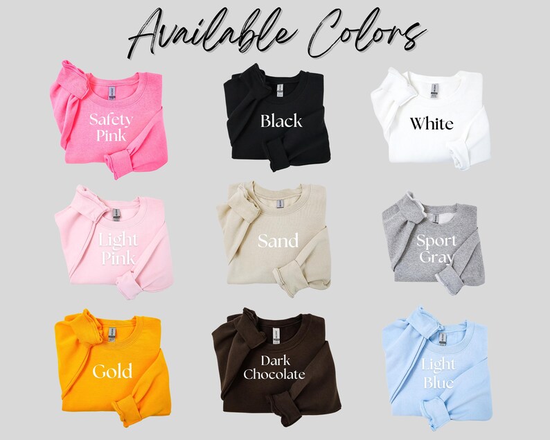May include: Nine crewneck sweatshirts are shown in a range of colours: Safety Pink, Black, White, Light Pink, Sand, Sport Grey, Gold, Dark Chocolate, and Light Blue. The text "Available Colors" is at the top.