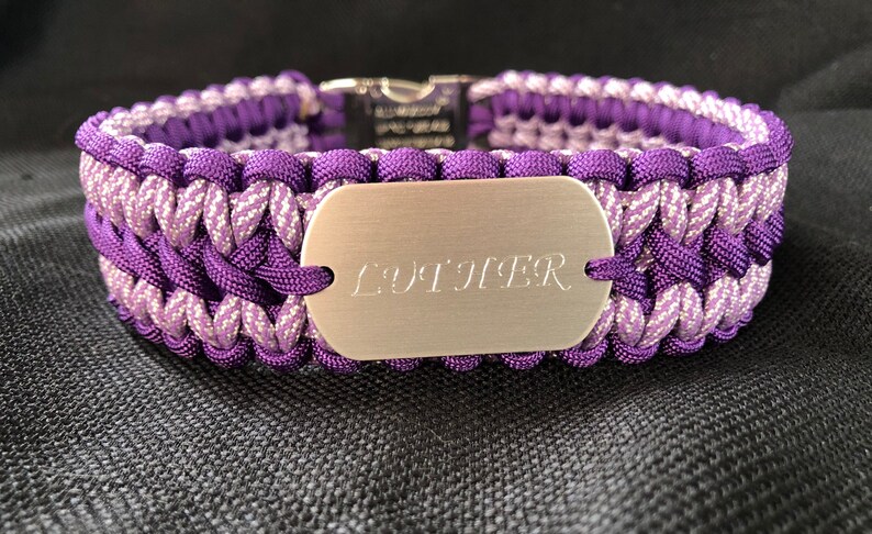 Pu&ograve; includere: Collare per cani in paracord viola e argento con un'etichetta argentata che dice "LUDIFER".