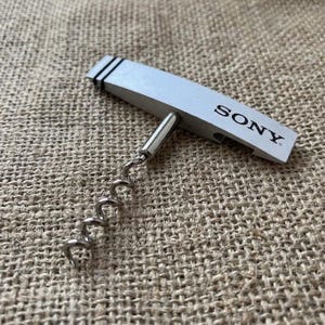 Abridor de garrafas vintage Sony PrimeSupport em metal, utensílio de bar de marca.
