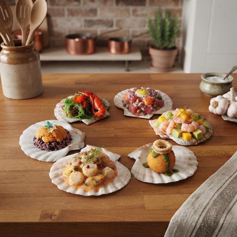 May include: Six individual scallop shells arranged on a wooden surface, each containing a distinct culinary preparation including seafood like shrimp, tuna, scallops, and uni, garnished with fresh herbs, greens, and colorful vegetable components.