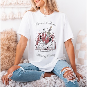 May include: A white ceramic mug with a black handle and the text "But First, Coffee" in a handwritten style. The mug is on a white surface. The mug is likely for hot beverages.