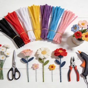 Pode incluir: Uma cole&ccedil;&atilde;o de materiais de artesanato, incluindo feixes de limpadores de cachimbo coloridos, flores de croch&ecirc;, tesouras, alicates e uma pistola de cola. As flores s&atilde;o em v&aacute;rias cores e estilos, perfeitas para projetos DIY.