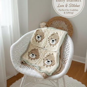May include: A handmade baby blanket with a bear design, draped over a white wicker chair. The blanket features four squares, each with a bear face in tan and cream colors. The text on the image reads "Handmade Baby Blanket Love & Stitches".
