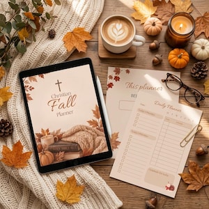 Op de afbeelding: Een digitale tablet met een Christian Fall Planner-omslag met een kruis, een bijbel en een pompoen, naast een geprint dagplannerblad, een kop koffie, een bril en verspreide herfstbladeren op een gebreide ondergrond.