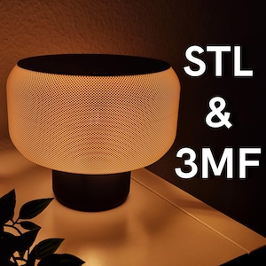 Puede incluir: Una lámpara de mesa cilíndrica moderna, con base y parte superior negras, y una pantalla texturizada de color naranja brillante. El texto "STL & 3MF" se muestra en blanco en el lado derecho de la lámpara.