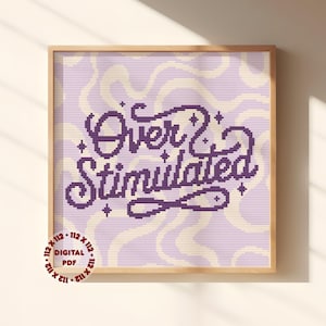 May include: A cross stitch pattern featuring the text Over Stimulated in dark purple, set against a light purple background with a wavy cream-coloured line pattern and small star accents. A circular badge in the corner reads 112 x 112 Digital PDF.