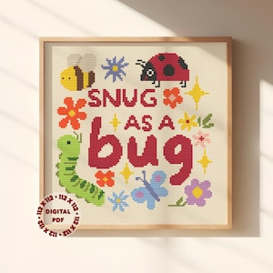 Könnte beinhalten: Kreuzstich-Kunstwerk in einem Holzrahmen mit dem Schriftzug "SNUG AS A BUG" in Rot. Das Design umfasst eine gelbe Biene, einen roten Marienkäfer, eine grüne Raupe und verschiedene bunte Blumen und Insekten. Ein digitales PDF ist ebenfalls verfügbar.