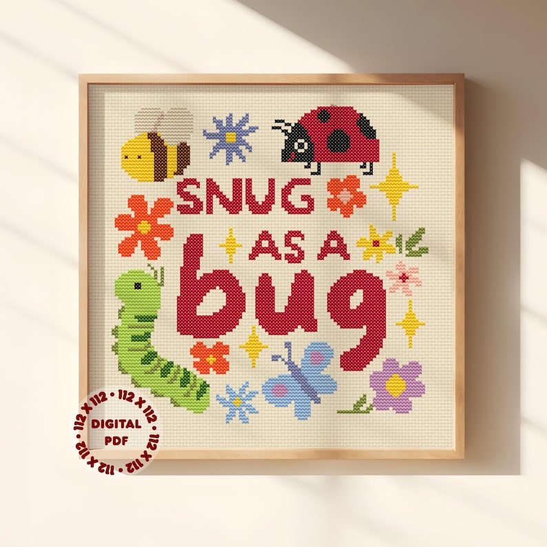 May include: A cross-stitch pattern featuring the text SNUG AS A BUG in red, surrounded by a yellow bee, a red ladybug, a green caterpillar, a blue butterfly, and various colorful flowers and yellow stars on a cream fabric background.