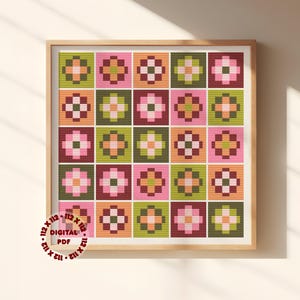 May include: A framed cross-stitch pattern featuring a grid of colorful floral designs. The squares showcase flowers in shades of pink, green, orange, and burgundy. The text "DIGITAL PDF" is visible. The frame is made of light-colored wood.