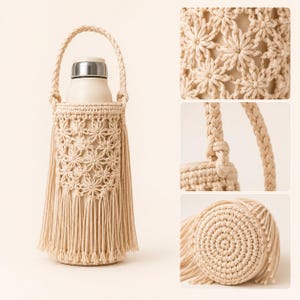 Op de afbeelding: Een beige macram&eacute; flessenhouder met een gevlochten handvat, een cilindervormig lichaam met een herhalend stervormig knooppatroon en lange franjes aan de onderkant. De houder bevat een gladde, lichtgekleurde fles met een zilveren dop.