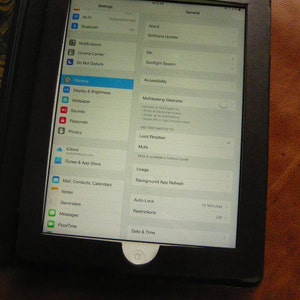 Puede incluir: Una captura de pantalla del men&uacute; de configuraci&oacute;n de un iPad. El men&uacute; incluye opciones para Wi-Fi, Bluetooth, Notificaciones, Centro de control, No molestar, Pantalla y brillo, Fondo de pantalla, Sonidos, C&oacute;digo de acceso, Privacidad, Nube, iTunes Store y App Store, Correo, Contactos, Calendarios, Notas, Recordatorios, Mensajes, FaceTime, General, Acerca de, Actualizaci&oacute;n de software, B&uacute;squeda de Spotlight, Accesibilidad, Gestos multitarea, Bloqueo de rotaci&oacute;n, Silencio, Uso, Actualizaci&oacute;n de aplicaciones en segundo plano, Bloqueo autom&aacute;tico, Restricciones y Fecha y hora.