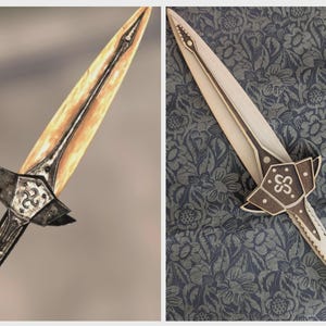May include: A decorative dagger with a metallic hilt and a blade. The blade has a gradient of yellow and orange, with a dark line down the center. The hilt features ornate metalwork and a ring at the base. The dagger is a fantasy-themed item.