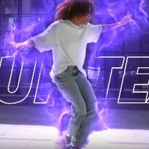 May include: A person in a white t-shirt and blue jeans, surrounded by purple energy, is captured mid-action. The words "YOUR TEXT" are outlined in white in front of the person. The background includes a metal fence and a building.