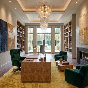 Puede incluir: Una lujosa oficina en casa con un gran escritorio de madera, sillas de terciopelo verde y una alfombra amarilla. Una gran l&aacute;mpara de ara&ntilde;a cuelga del techo y estanter&iacute;as bordean las paredes. Grandes ventanas ofrecen vistas al exterior.