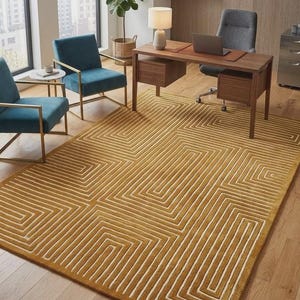 Op de afbeelding: Mosterdgele vloerkleed met geometrisch patroon en een herhalend hoekig ontwerp in crème. Het kleed staat in een kantoor met blauwgroene stoelen en een houten bureau. Afmetingen: ongeveer 240 x 300 cm.