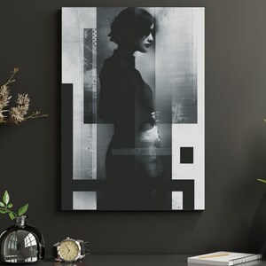 May include: Black and white abstract art print featuring a silhouette of a person against a geometric background. The artwork is mounted on a canvas and displayed on a dark gray wall. A watch, a vase, and a notebook are on the shelf below.
