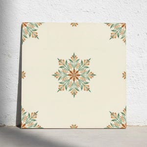Op de afbeelding: Een vierkante keramische tegel met een gebroken witte basiskleur. Het midden is voorzien van een symmetrisch bloemmotief in saliegroen en terracotta oranje. Soortgelijke kleinere bladpatronen bevinden zich op elke hoek en de randen.