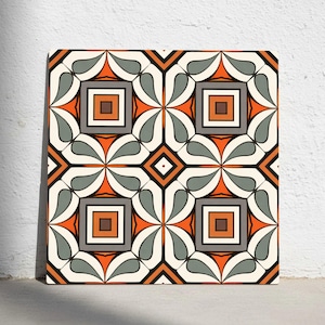 Op de afbeelding: Vierkante decoratieve tegel met een herhalend geometrisch patroon. Het ontwerp heeft oranje, grijze, bruine en crèmekleuren. Het patroon bevat vierkanten, ruiten en gestileerde bladvormen, waardoor een symmetrisch en visueel aantrekkelijk ontwerp ontstaat.