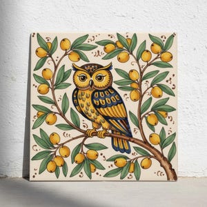 Peut inclure: Un carreau de céramique carré présentant une illustration centrale d'un hibou aux plumes jaunes et bleu foncé. Le hibou est perché sur une branche brune entourée de feuilles vertes et de petites baies jaunes sur un fond crème.