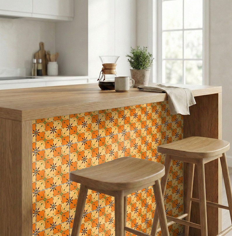 May include: A kitchen island with a wooden countertop and a decorative tile backsplash. The tiles feature a repeating pattern of orange, yellow, and green floral designs. Two wooden stools are positioned in front of the island.
