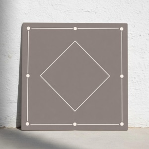 Puede incluir: Una baldosa decorativa cuadrada de color topo con un borde blanco y una forma de diamante blanco en el centro. Se colocan puntos blancos en cada esquina y a lo largo de los lados de la baldosa.