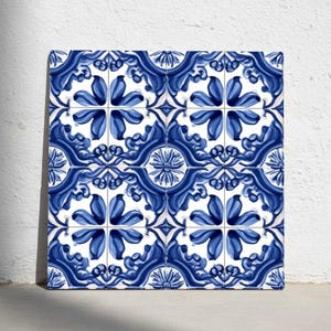 Puede incluir: Azulejos cuadrados de cerámica con un patrón floral azul y blanco repetido. El diseño presenta flores estilizadas y hojas arremolinadas en tonos azules sobre un fondo blanco. Los azulejos están dispuestos en una cuadrícula, creando una superficie decorativa cohesiva.