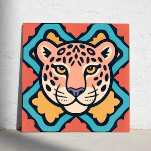 May include: Square artwork depicting a stylized leopard face with yellow eyes, black spots, and a purple nose. The leopard is set against a geometric background of teal, orange, and yellow. The artwork is displayed on a white wall.