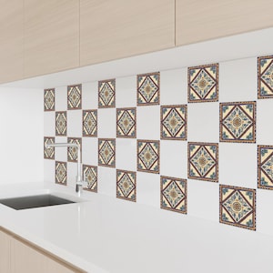 May include: Decorative square tiles with a repeating pattern of blue, yellow, and brown geometric designs. The tiles are arranged on a white wall, creating a backsplash effect. The overall aesthetic is a blend of traditional and modern design.