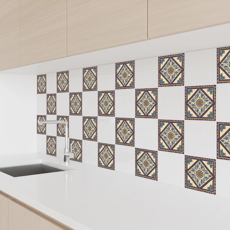 May include: Decorative square tiles with a repeating pattern of blue, yellow, and brown geometric designs. The tiles are arranged on a white wall, creating a backsplash effect. The overall aesthetic is a blend of traditional and modern design.