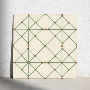 May include: A square tile featuring a cream-coloured background with a geometric pattern of thin sage green lines forming a grid of diamonds and squares. Small, solid brown circular dots are positioned at each intersection of the green lines.