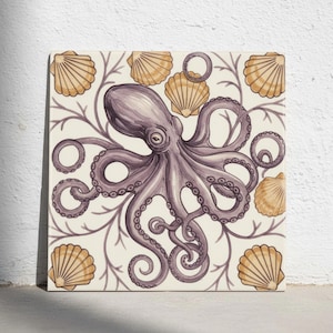Op de afbeelding: Een vierkante keramische tegel met een centrale illustratie van een paarse octopus, omringd door goudgele sint-jakobsschelpen en dunne, vertakte zeewierpatronen op een crèmekleurige achtergrond. Het ontwerp is symmetrisch en gedetailleerd.