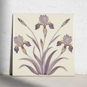 May include: A square ceramic tile featuring a hand-painted botanical illustration of three purple iris flowers with yellow accents. The design includes long, slender green-grey leaves and stems set against a solid off-white background.