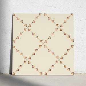 Puede incluir: Un azulejo de cerámica cuadrado con fondo color crema que presenta un patrón de rejilla de diamantes repetitivo. La rejilla está formada por líneas finas marrones acentuadas con pequeños motivos estilizados en forma de hoja en tonos rojo, naranja y marrón oscuro.