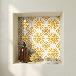 May include: A bathroom alcove displays white tiles patterned with yellow suns. A brown soap dispenser, natural sponge, and soap dish with soap are on the shelf. The alcove is set into a white wall.