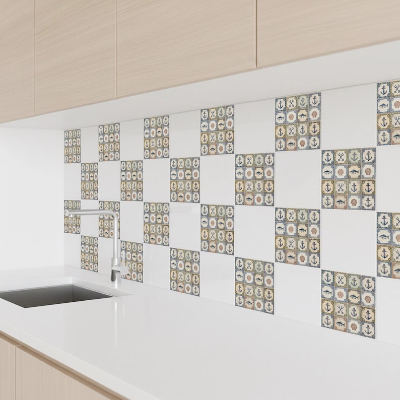 May include: White and patterned ceramic tiles with nautical motifs, including anchors, shells, and fish. The tiles are arranged in a checkerboard pattern, creating a decorative backsplash. The tiles are installed above a white countertop.